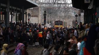 Rangkaian kereta rel listrik (KRL) melintas di jalur rel Stasiun Manggarai, Jakarta, Kamis (13/2).  [Suara.com/Angga Budhiyanto] 
