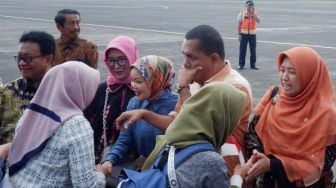 Anggota Komisi IX DPR RI Kurniasih Mufidayati (Hijab orange) bersama rombongan menyalami sejumlah WNI yang telah menjalani observasi Virus Corona di Natuna saat tiba di Bandara Halim Perdana Kusuma, Jakarta Timur, Sabtu (15/2).  [Foto/dok DPR]