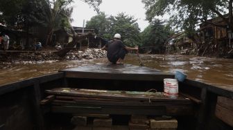 Seorang warga mengoperasikan perahu eretan untuk menyeberangi Kali Ciliwung di kawasan Manggarai, Jakarta, Jumat (14/2). [Suara.com/Angga Budhiyanto]