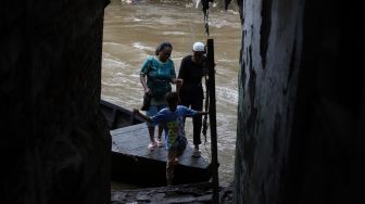 Penumpang turun dari perahu eretan usai menyeberangi Kali Ciliwung di kawasan Manggarai, Jakarta, Jumat (14/2). [Suara.com/Angga Budhiyanto]