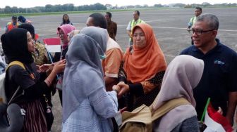 Anggota Komisi IX DPR RI Kurniasih Mufidayati (Hijab orange) bersama rombongan menyalami sejumlah WNI yang telah menjalani observasi Virus Corona di Natuna saat tiba di Bandara Halim Perdana Kusuma, Jakarta Timur, Sabtu (15/2).  [Foto/dok DPR]