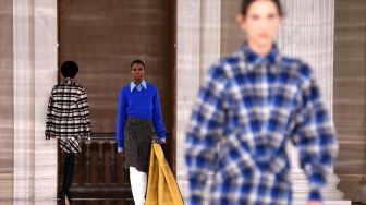 Model berpose saat membawakan busana rancangan Victoria Beckham pada London Fashion Week di London, Minggu (16/2). [DANIEL LEAL-OLIVAS / AFP]