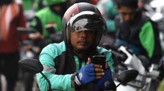 Pengemudi ojek online menunggu penumpang di kawasan Pasar Minggu, Jakarta Selatan, Senin (17/2). [Suara.com/Angga Budhiyanto]