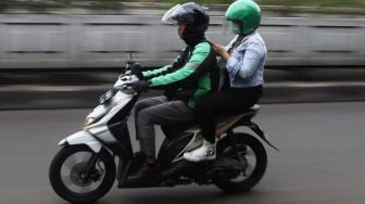 Pengemudi ojek online membawa penumpang melintas di kawasan Pasar Minggu, Jakarta Selatan, Senin (17/2). [Suara.com/Angga Budhiyanto]