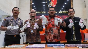 Direktur Dirtipideksus Brigadir Jendral Daniel Monang (kedua kanan) saat menunjukan barang bukti sejumlah uang palsu yang disita di Bareskrim Mabes Polri, Jakarta Selatan, Selasa (18/02). [Suara.com/Alfian Winanto]