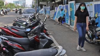 Pejalan kaki yang melintas di Jalan Gajah Mada, Jakarta Barat, Rabu (19/02). [Suara.com/Alfian Winanto]