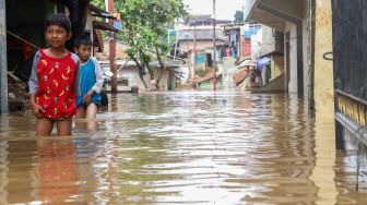 Seorang anak melintasi banjir di Pejaten Timur, Jakarta Selatan, Kamis (20/02).  [Suara.com/Alfian Winanto]