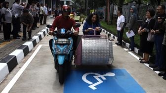 Seorang penyandang disabilitas menaiki kendaraan khusus saat peresmian area parkir khusus kendaraan penyandang disabilitas di Stasiun MRT Lebak Bulus, Jakarta, Kamis (20/2).  [Suara.com/Angga Budhiyanto]