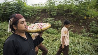 Warga kampung adat Cireundeu membawa bunga saat upacara adat peringatan Hari Peduli Sampah Nasional (HPSN) 2020 di lokasi tragedi longsor sampah eks TPA Leuwigajah, Cimahi, Jawa Barat, Jumat (21/2). [ANTARA FOTO/M Agung Rajasa]