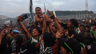 Pesepakbola Persebaya Oktavianus Fernando (tengah) diangkat para suporter usai menerima penghargaan sebagai juara Piala Gubernur Jawa Timur 2020 di Stadion Gelora Delta Sidoarjo, Jawa TImur, Kamis (20/2). [ANTARA FOTO/Zabur Karuru]