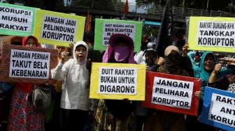 Sejumlah massa aksi membawa poster saat aksi unjuk rasa terkait "Berantas Mega Korupsi, Selamatkan NKRI" di Jalan Merdeka Barat, Jakarta, Jumat (21/2). [Suara.com/Angga Budhiyanto]