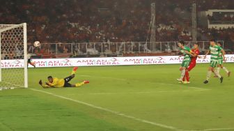 Tendangan Striker Persija Taufik Hidayat yang masih memebentur mistar gawang Geylang International FC dalam laga persahabatan di Stadion Utama Gelora Bung Karno, Jakarta, Minggu (24/02). [Suara.com/Alfian Winanto]