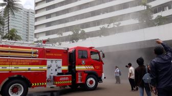 Mobil pemadam kebakaran di Gedung Nusantara III DPR RI yang dipenuhi asap, Jakarta, Senin (24/2).  [Suara.com/Novian]
