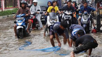 Asyiknya Warga Bekasi Mencari Ikan di Tengah Banjir