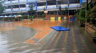 Suasana banjir yang menggenangi sekolah SMPN 8, Jakarta, Selasa (25/2). [Suara.com/Oke  Atmaja]
