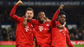 Striker Bayern Munich Robert Lewandowski (kiri) merayakan golnya dengan bek Bayern Munich David Alaba (tengah) dan gelandang Bayern Munich Alphonso Davies (kanan) setelah mencetak gol ketiga mereka selama pertandingan leg pertama babak 16 besar  Liga Champions antara Chelsea melawan Bayern Munich di Stamford Bridge, London, Inggris, Rabu (26/2) dini hari WIB
[Glyn KIRK / AFP]
