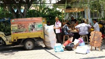 Petugas bank sampah mengumpulkan sampah yang ditukarkan dengan kopi di Kampus Unair Banyuwangi, Jawa Timur, Kamis (27/2). [ANTARA FOTO/Budi Candra Setya]