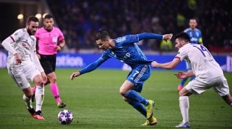 Pemain depan Juventus Cristiano Ronaldo (C) bersaing untuk mendapatkan bola dengan pemain belakang Lyon Leo Dubois (kanan) dan pemain tengah Lyon Lucas Tousart (kiri) selama putaran leg pertama babak 16 besar Liga Champions antara Lyon melawan Juventus di Stadion Parque Olympique Lyonnais, Perancis, Kamis (27/2) dini hari WIB. [FRANCK FIFE / AFP]
