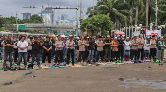 Para pengemudi Ojol (Ojek Online) menggelar Salat Jumat bareng Polisi di depan Gedung  DPR dan MPR RI, Jakarta, Jumat (28/02). . [Suara.com/Alfian Winanto]
