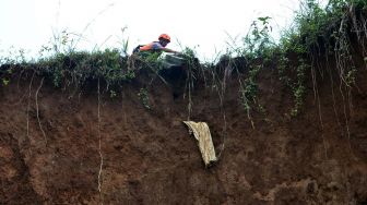 Anggota BPBD Kota Bogor melakukan evakuasi makam di TPU Kebon Nanas yang terdampak tanah longsor di Kampung Nanggerang RT 03/06, Rangga Mekar, Kelurahan Pamoyanan, Kota Bogor, Jawa Barat, Jumat (28/2). [ANTARA FOTO/Arif Firmansyah]