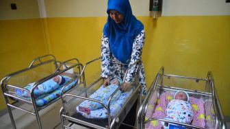 Perawat menyelimuti tiga dari empat bayi yang lahir pada 29 Februari 2020 di Rumah Sakit Aisyiyah Kudus, Kudus, Jawa Tengah (29/2).  [ANTARA FOTO/Yusuf Nugroho]