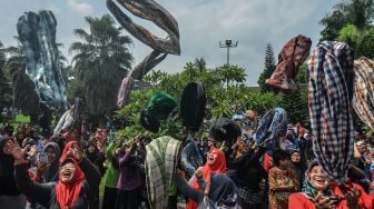 Warga mengikuti permainan tradisional "Sasarungan" pada peringatan Mieling Poe Basa Indung Sadunya atau Hari Bahasa Ibu Internasional di Alun-alun Kota Tasikmalaya, Jawa Barat, Minggu (1/3). [ANTARA FOTO/Adeng Bustomi]