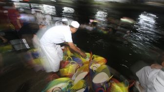 Sejumlah relawan haul KH Muhammad Zaini Abdul Ghani (Abah Guru Sekumpul) bergotong royong membersihkan beras di Irigasi Sekumpul, Martapura, Kalimantan Selatan, Sabtu (29/2) malam.[ANTARA FOTO/Bayu Pratama S] 