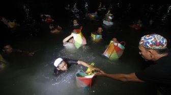 Sejumlah relawan haul KH Muhammad Zaini Abdul Ghani (Abah Guru Sekumpul) bergotong royong membersihkan beras di Irigasi Sekumpul, Martapura, Kalimantan Selatan, Sabtu (29/2) malam.[ANTARA FOTO/Bayu Pratama S] 