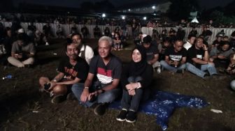 Ganjar Pranowo Lesehan Pakai Jas Hujan Nonton White Snake di JogjaROCKarta