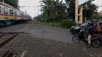 Kereta melintas di pelintasan kereta Bumi Bintaro Permai, Pesanggrahan, Jakarta Selatan, Senin (2/3).  [Suara.com/Angga Budhiyanto]