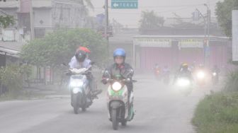 Pengendara motor menutup wajahnya saat melintas dan terjadi hujan abu di Mojosongo, Boyolali, Jawa Tengah, Selasa (3/3).  [ANTARA FOTO/Aloysius Jarot Nugroho]
