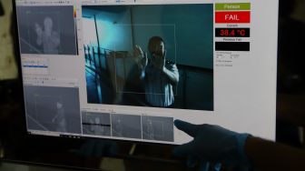 Petugas menunjukkan cara kerja mesin thermal scanner saat simulasi pencegahan penyebaran virus corona di Terminal Penumpang Tanjung Priok, Jakarta Utara, Selasa (3/3). [Suara.com/Angga Budhiyanto]
