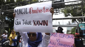 Sejumlah massa buruh perempuan yang tergabung dalam Federasi Serikat Pekerja Metal Indonesia (FSPMI) - Konfederasi Serikat Pekerja Indonesia (KSPI) melakukan longmarch menuju depan gedung Kementerian Pemberdayaan Perempuan dan Perlindungan Anak Republik Indonesia, Jalan Medan Merdeka Barat, Jakarta Pusat, Jumat (6/3). [Suara.com/Angga Budhiyanto]