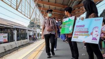 Petugas yang membawa poster cegah Corona di Stasiun Depok, Jawa Barat, Jumat (6/3). [Suara.com/Alfian Winanto]