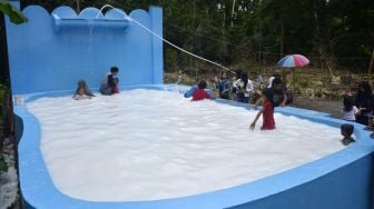 Sejumlah warga bermain di kolam air berwarna putih menyerupai air susu di Kecamatan Bontomarannu, Kabupaten Gowa, Sulawesi Selatan, Sabtu (7/3). [ANTARA FOTO/Abriawan Abhe] 