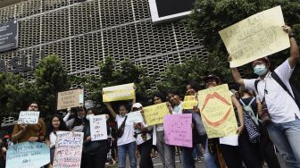 Sejumlah massa yang tergabung dalam Aliansi Gerakan Perempuan Anti-Kekerasan (GERAK Perempuan) membawa poster saat melakukan aksi unjuk rasa di depan kantor Bawaslu, Jakarta, Minggu (8/3). [Suara.com/Angga Budhiyanto]