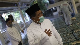 Ketua Umum Pengurus Pusat Dewan Masjid Indonesia Mohammad Jusuf Kalla meninjau penyemprotan cairan disinfektan di Masjid Nurul Hidayah, Jalan Brawijaya XII, Jakarta Selatan, Minggu (8/3). [Suara.com/Angga Budhiyanto]