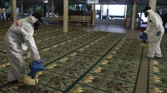 Petugas menyemprotkan cairan disinfektan di Masjid Nurul Hidayah, Jalan Brawijaya XII, Jakarta Selatan, Minggu (8/3). [Suara.com/Angga Budhiyanto]