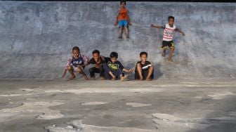 Anak-anak bermain perosotan di area Skate park Fly Over Slipi, Jakarta Pusat, Senin (9/3). [Suara.com/Alfian Winanto]
