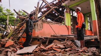 Warga melihat bangunan ambruk akibat gempa bumi di kecamatan Kabandungan, Sukabumi, Jawa Barat, Rabu (11/3). [ANTARA FOTO/Budiyanto]
