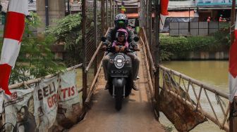 Pengendara motor melewati JPO (Jembatan Penyeberangan Orang) yang ada di Jl. KH. Noer Ali, Kalimalang, Bekasi, Kamis (12/3). [Suara.com/Alfian Winanto]
