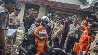 Tersangka Budi Rahmat membawa korban dengan motor saat reka ulang pembunuhan kepada anaknya sendiri pada rekontruksi di Cilembang, Kota Tasikmalaya, Jawa Barat, Kamis (27/1). [ANTARA FOTO/Adeng Bustomi]