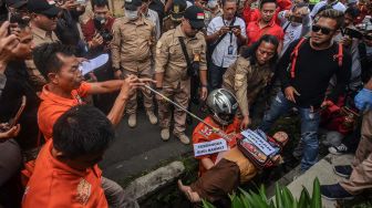 Tersangka Budi Rahmat menggendong korban saat reka ulang pembunuhan kepada anaknya sendiri pada rekontruksi di Cilembang, Kota Tasikmalaya, Jawa Barat, Kamis (12/3). [ANTARA FOTO/Adeng Bustomi]
