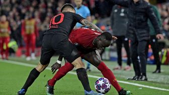 Striker Atletico Madrid Angel Correa (kiri) bersaing dengan striker Liverpool Sadio Mane selama pertandingan Liga Champions babak 16 besar antara Liverpool melawan Atletico Madrid di Anfield, Liverpool, Inggris, Kamis (12/3) dini hari WIB. [JAVIER SORIANO / AFP]