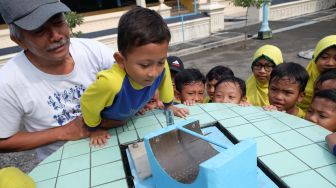 Seorang siswa SD Muhammadiyah 2 Kauman mengamati jam Istiwak atau jam matahari saat kegiatan belajar luar kelas di halaman Masjid Agung Solo, Jawa Tengah, Kamis(12/3).   [ANTARA FOTO/Maulana Surya]