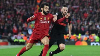 Gelandang Liverpool Mohamed Salah bersaing dengan gelandang Atletico Madrid Koke selama pertandingan Liga Champions babak 16 besar antara Liverpool melawan Atletico Madrid di Anfield, Liverpool, Inggris, Kamis (12/3) dini hari WIB. [Paul ELLIS / AFP]
