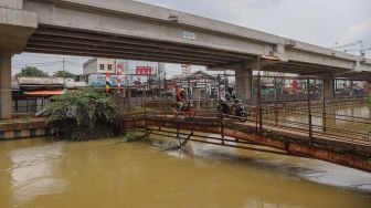 JPO (Jembatan Penyeberangan Orang) dilewati motor di Jl. KH. Noer Ali, Kalimalang, Bekasi, Kamis (12/3). [Suara.com/Alfian Winanto]