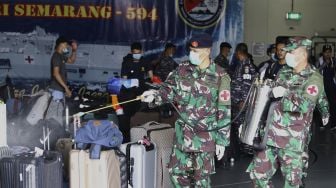 Anggota TNI menyemprotkan cairan desinfektan ke barang-barang milik WNI Anak Buah Kapal (ABK) World Dream tiba di Dermaga Komando Lintas Laut Militer (Kolinlamil), Tanjung Priok, Jakarta Utara, Sabtu (14/3). [Suara.com/Angga Budhiyanto]