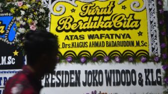 Warga melintasi karangan-karangan bunga yang terpasang di rumah duka almarhum Kepala Pusat Pelaporan Analisis dan Transaksi Keuangan (PPATK) Kiagus Ahmad Badaruddin di Tebet, Jakarta, Sabtu (14/3).   [ANTARA FOTO/Aditya Pradana Putra]