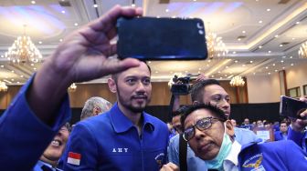 Ketua Umum Partai Demokrat yang baru, Agus Harimurti Yudhoyono (tengah) melayani swafoto kader saat Kongres V Partai Demokrat di Jakarta, Minggu (15/3). [ANTARA FOTO/M Risyal Hidayat]